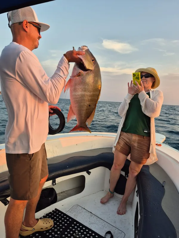 Visser met een vis op een boot tijdens een vistrip op Aruba
